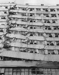 an old building with broken windows and lots of debris hanging off the side of it