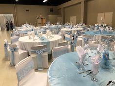 tables and chairs are set up with blue sashers, white tablecloths and silverware