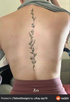 the back of a woman's body with tattoos on her upper and lower back