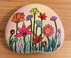 a painted rock sitting on top of a wooden table