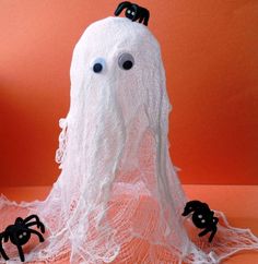 there is a fake white ghost with two black spider legs on it's head