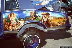 an old car painted with images of people and animals on it's paint job