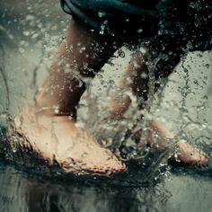 a person standing in the water with their feet up