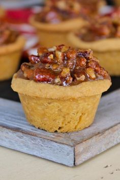 small cupcakes with nuts on top sitting on a tray