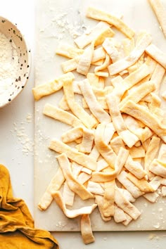 a cutting board topped with lots of cut up pieces of food next to a bowl