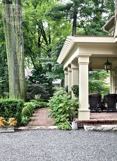 an outdoor gazebo surrounded by greenery and trees with chairs on the patio area