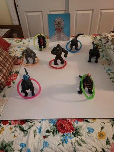 a bunch of small toy animals sitting on top of a white sheet covered bed in a room