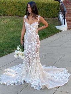 a woman in a wedding dress standing on the sidewalk