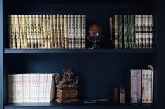 the bookshelf is filled with many different types of books and vases on it