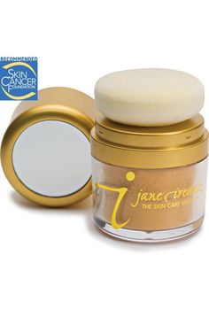 an open jar of loose powder with a mirror on the lid and gold rimmed lid