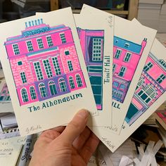 three pink and blue buildings are on top of papers