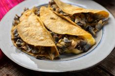 two tortillas on a plate with mushrooms and cheese