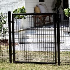 a black gate is in front of a house