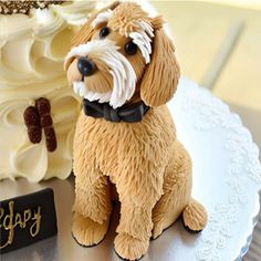 a dog figurine sitting on top of a white plate next to a cake