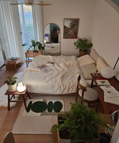 a bed room with a neatly made bed and lots of plants