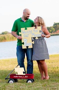 a man and woman standing next to each other holding a sign