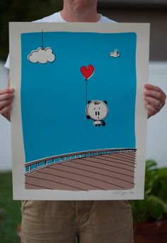 a man holding up a drawing of a panda bear with a heart balloon