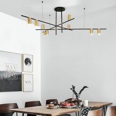 a dining room table and chairs in front of a white wall