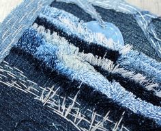 an old pair of blue jeans with fraying on the bottom and sides, sitting on a wooden surface