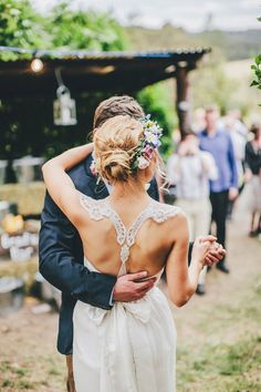 a bride and groom hug as they walk down the aisle at their outdoor wedding ceremony