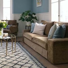 a living room with two couches and a coffee table in front of the window