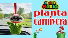 a stuffed animal hanging from the side of a car window in front of a sign that says, super mario planta carnivora