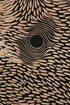 an intricately designed piece of wood with wavy lines and circles on the surface, as well as a circular hole in the center