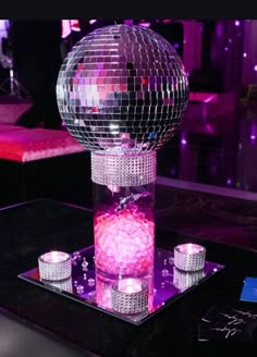 a table topped with a disco ball and candles