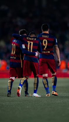 three soccer players are standing together on the field