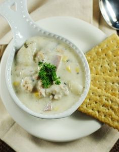 a white bowl filled with soup next to crackers