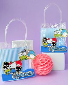 two bags with cartoon characters on them sitting next to a tissue paper ball and holder