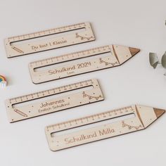 three wooden rulers with the names of different countries and numbers on them are shown next to a flower