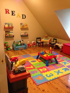 a child's playroom with toys and books on the floor in an attic