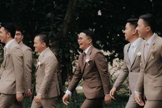 a group of men walking across a lush green field