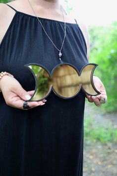 a woman holding two mirrors in her hands