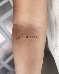 a person with a tattoo on their arm that says,'love'in cursive writing