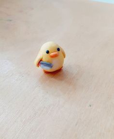 a small yellow toy sitting on top of a wooden table