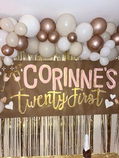 a sign that says corinne's twenty first surrounded by balloons