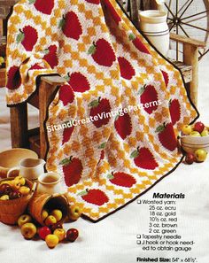 an advertisement with apples on the table and in front of it is a blanket that has been crocheted