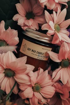 pink flowers surrounding a jar of soy wax candle