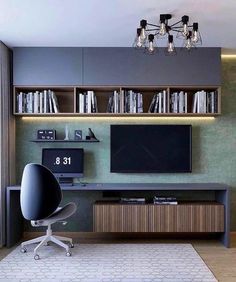 a room with a desk, bookshelf and television on it's wall