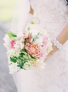 a bride holding a bouquet of flowers in her hand