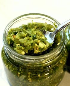 a jar filled with green pesto and a spoon