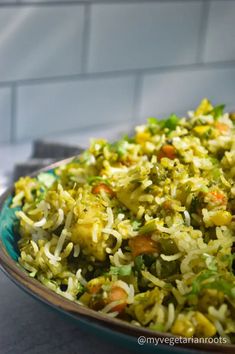 a bowl filled with rice and vegetables on top of a table