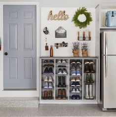 a white refrigerator freezer sitting inside of a kitchen next to a metal shelf filled with shoes