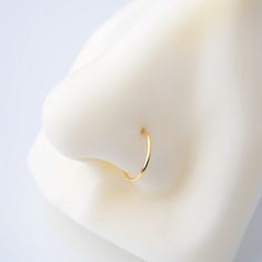 a gold ring sitting on top of a white surface