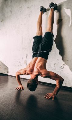 a man is doing a handstand on the floor