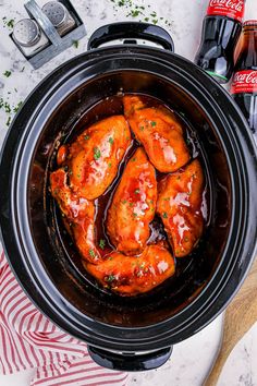 a slow cooker filled with chicken wings and sauce