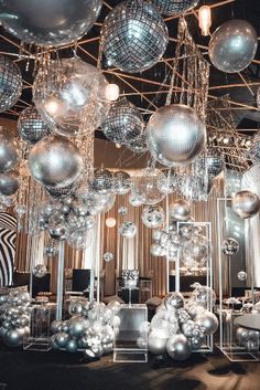 a room filled with lots of shiny silver balls and chandeliers hanging from the ceiling