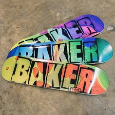 three colorful skateboards are laying on the ground